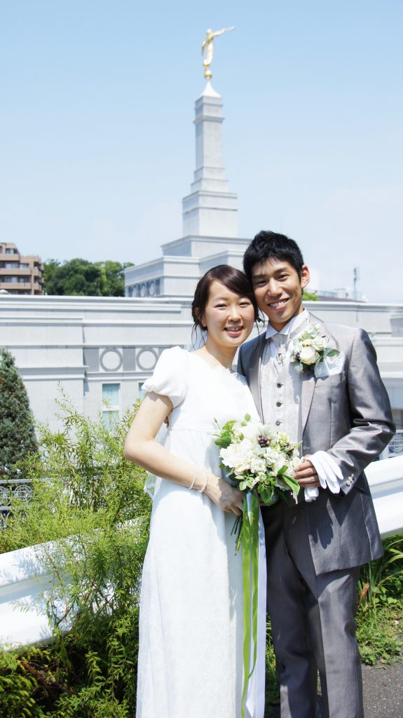 福岡神殿の前に立つ結婚したての夫婦