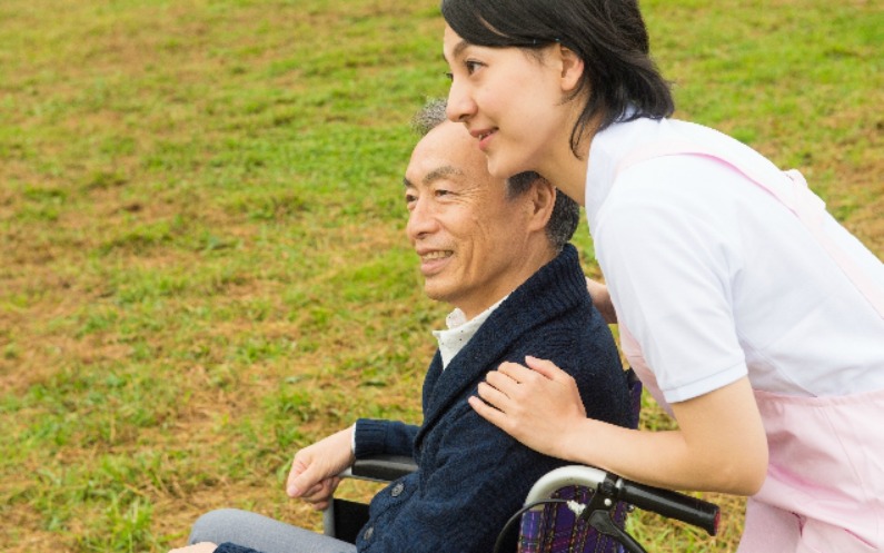 車椅子の男性を助ける女性