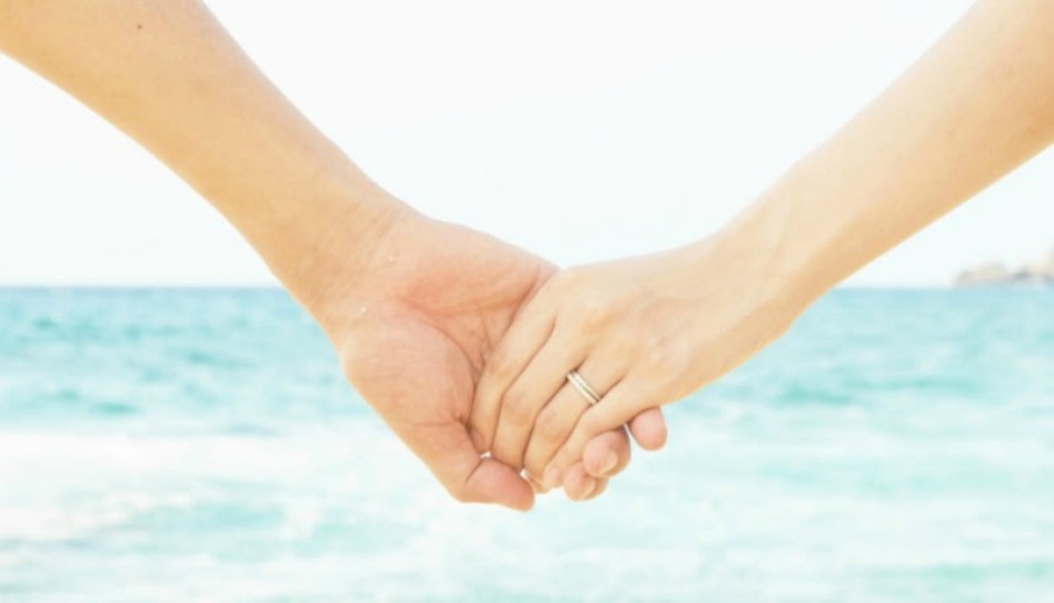 海辺で繋いだ夫婦の手