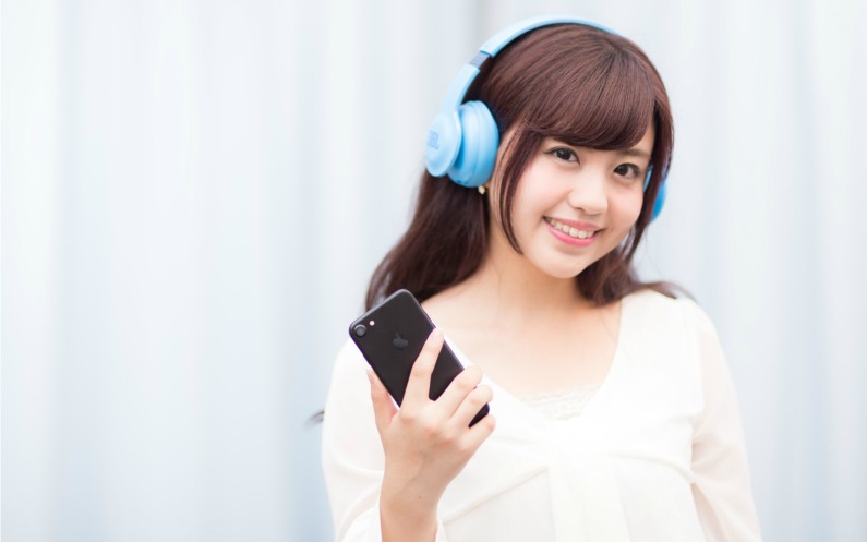 ヘッドフォンで聖典学習する女性