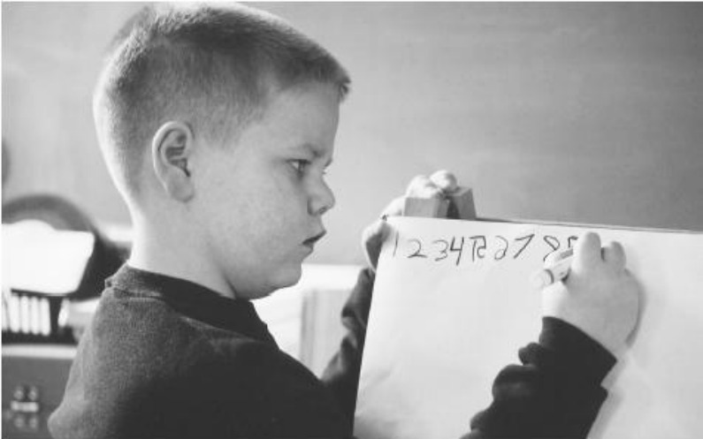 数字を画用紙に書く12歳のジェレミー