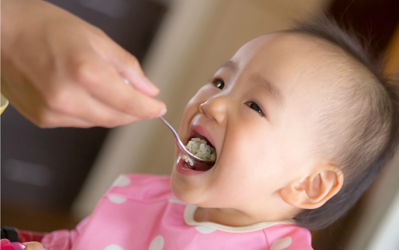 ご飯を食べさせてもらう子供