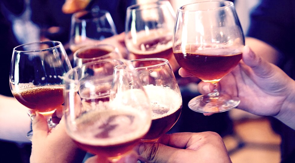 アルコール飲料で乾杯する人たちの手元