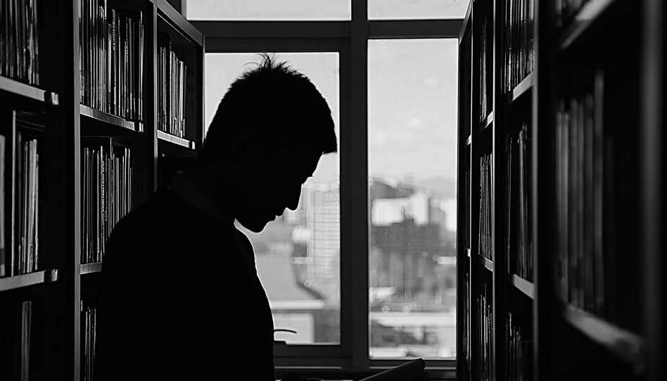 図書館で本を探す男性