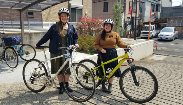 姉妹宣教師が自転車をそれぞれ持って並んで立っている様子