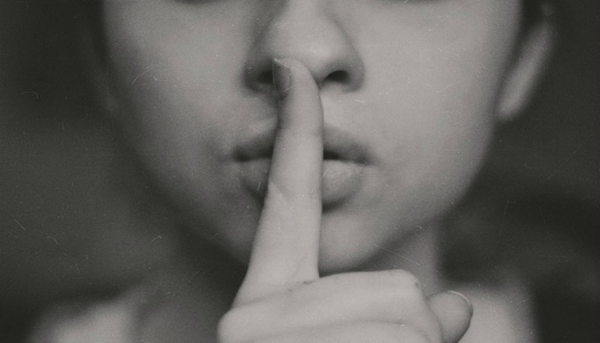 人差し指を口に当てた人のクロースップ写真