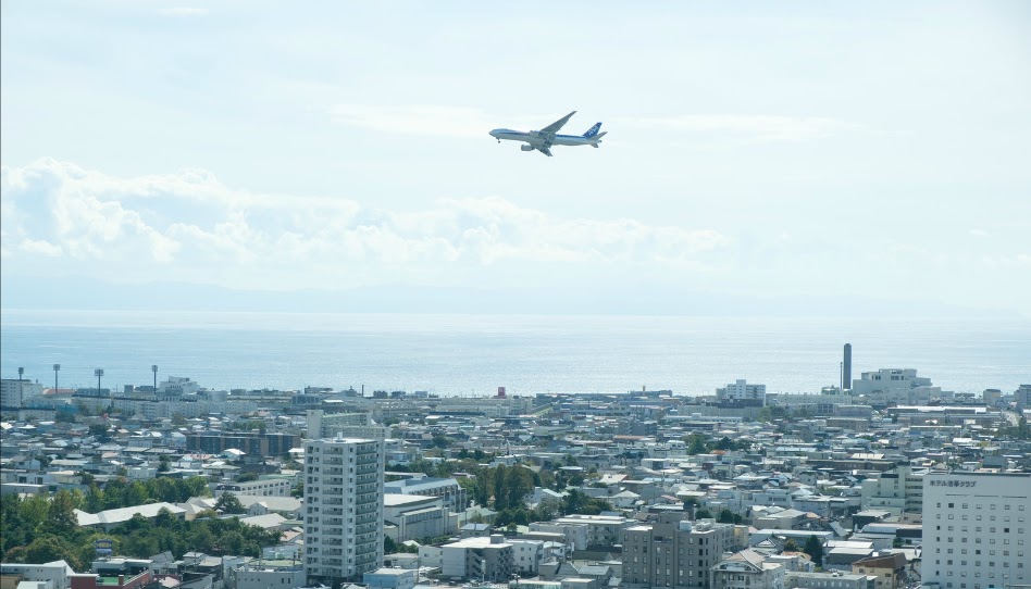 市街の上を飛行機が飛んでいる様子