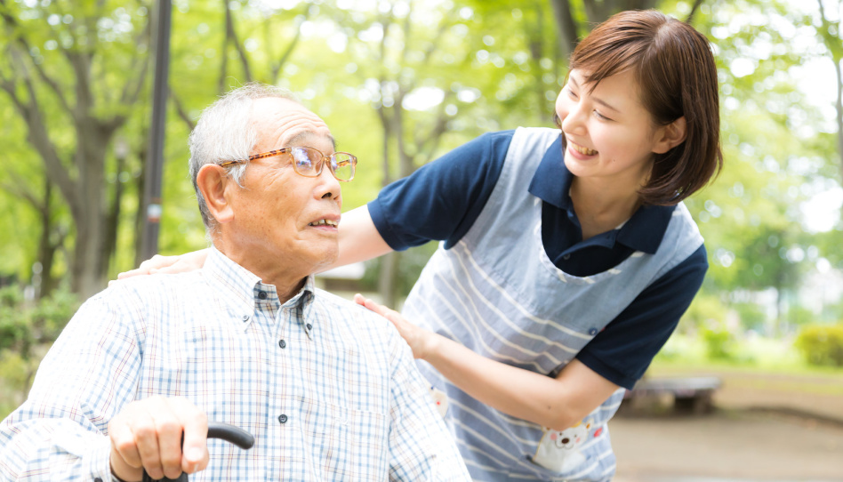 気を利かせ老人に話しかける介護士