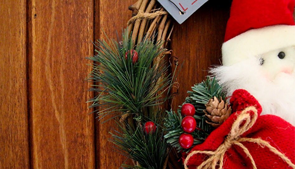 ツタのクリスマスリースに飾られたサンタの人形