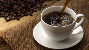 コーヒー豆が置かれたテーブルでカップに注がれるコーヒー