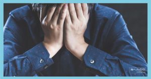 手で顔を覆い悩む男性