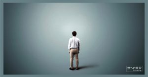 薄暗い中でたたずむ男性の後ろ姿