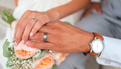 結婚式のブーケと重ね合う新郎新婦の左手
