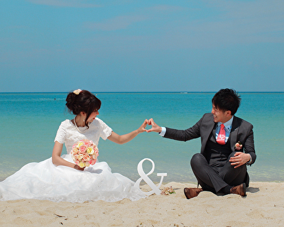 結婚は死んで終わりじゃない。ビーチで仲良くウェディングフォトを撮る新婚カップル