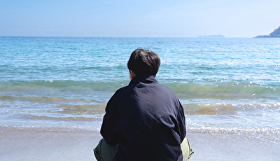 浜辺で物思いにふける男性